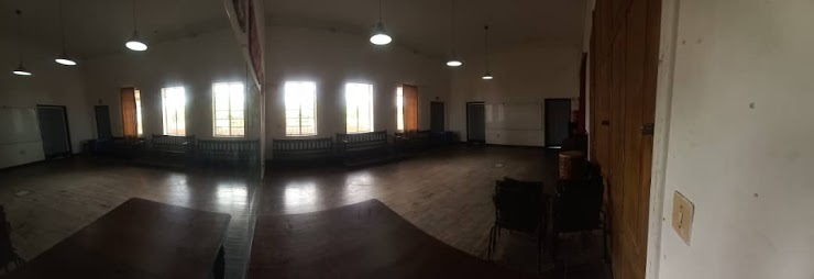 Large rehearsal room with wooden floor and windows